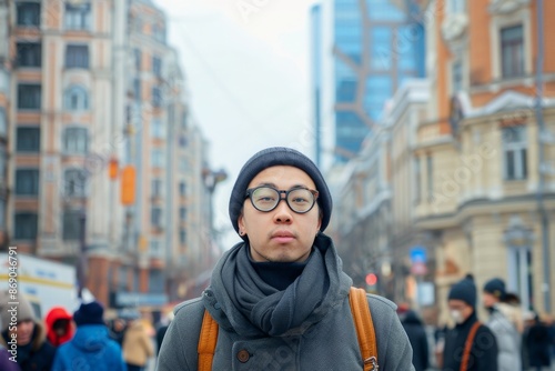 Portrait of fashionably dressed asian tourist in stylish glasses walking in center of capital