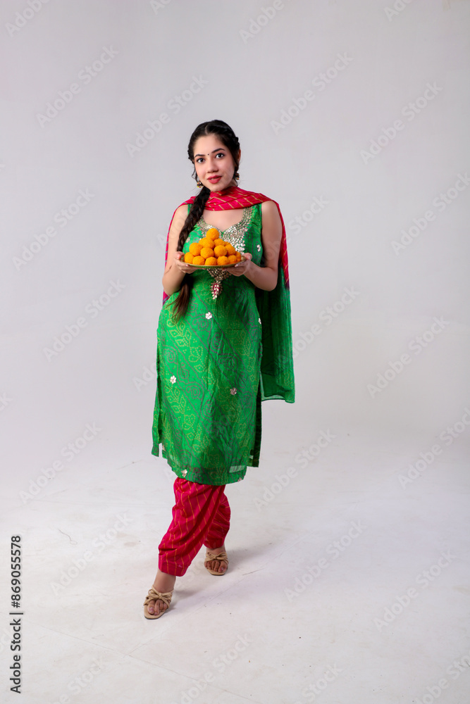 Studio Shoot Of Appealing Woman In Salwar Kameez Holding Laddu Plate In Hand Studio Shoot Of Appealing Woman In Salwar Kameez Holding Laddu Plate In Hand