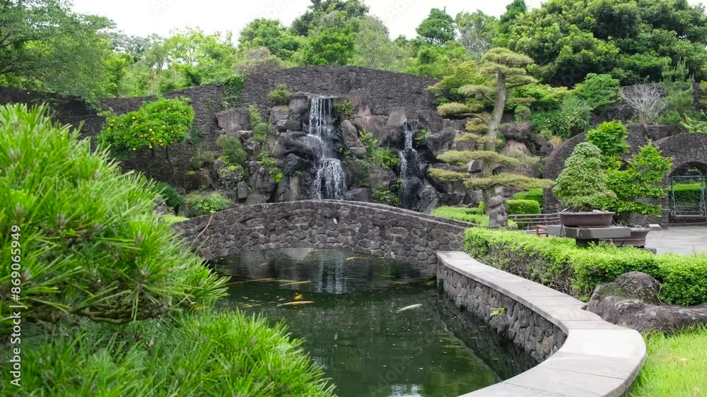 Decorative waterfall at pond of Spirited garden in Jeju island, South Korea. Decorative waterfall at pond of Spirited garden in Jeju island, South Korea.