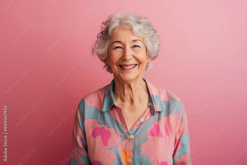 Smiling senior woman wearing casual shirt on pink background Smiling senior woman wearing casual shirt on pink background
