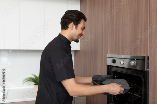Картината върху платно Young inexperienced cooker trying to open the oven but something going wrong