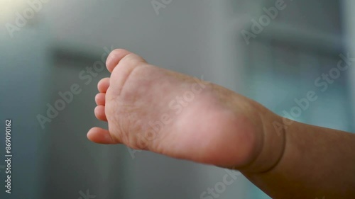 Close up of cute baby feet of little baby on chair at home and practicing movement, copy space. photo