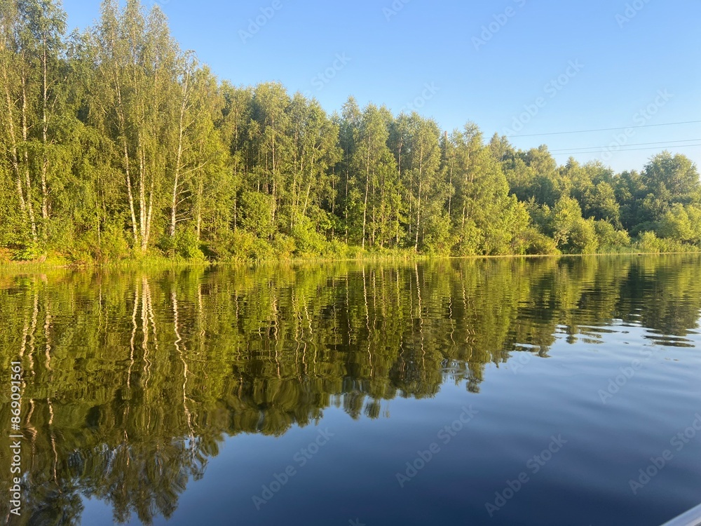 beautiful lake on the shore forest with reflection in water blue sky in reflection of water. beautiful lake on the shore forest with reflection in water blue sky in reflection of water.