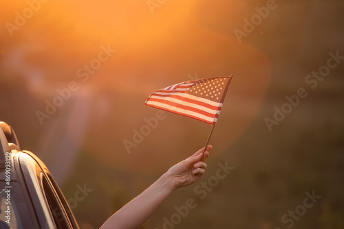 Photography Woma in the car holding a waving american USA flag.