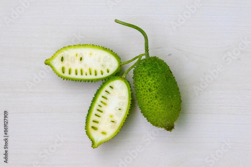 Φωτογραφία Sliced and whole spiny gourd green vegetable on light white wooden background