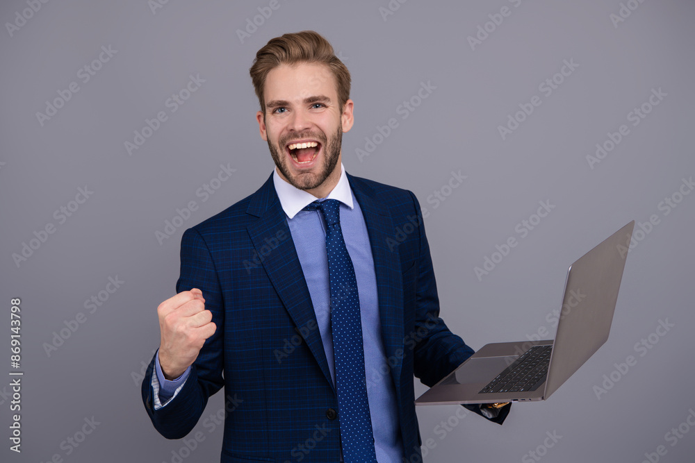 Successful businessman using laptop isolated on grey. Freelancer working online. Man has online blog. Businessman in suit with laptop in office. Remote online working. Business blog success Successful businessman using laptop isolated on grey. Freelancer working online. Man has online blog. Businessman in suit with laptop in office. Remote online working. Business blog success
