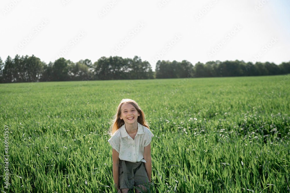 Carefree girl standing in grassy field under clear sky Carefree girl standing in grassy field under clear sky