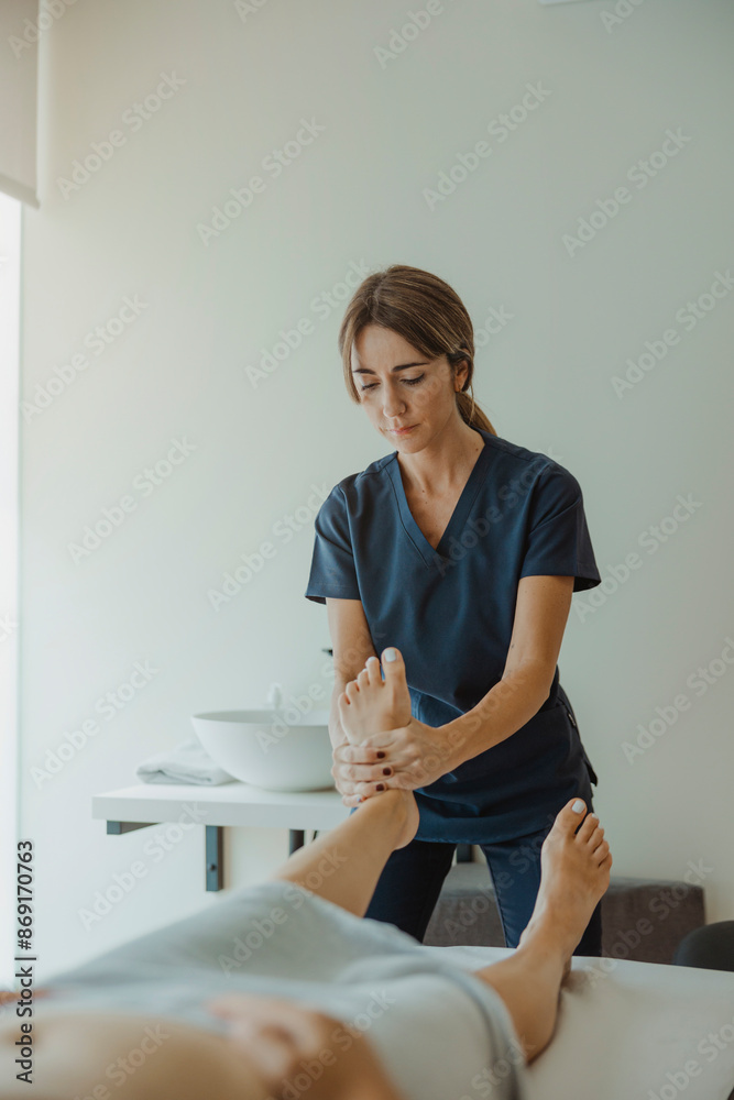 Physiotherapist examining patient's feet in clinic Physiotherapist examining patient's feet in clinic