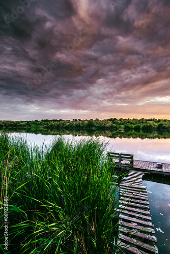 River and purple clouds . Water and reflections on water. Woods and beautifyl river .  photo