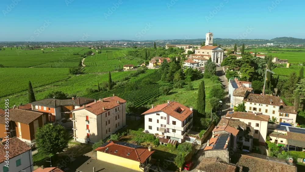 Aerial drone film of small village or town with winery and ancient historic medieval church in Valpolicella wine region in northern Italy surrounded by green grape and vineyard. Aerial drone film of small village or town with winery and ancient historic medieval church in Valpolicella wine region in northern Italy surrounded by green grape and vineyard.