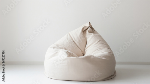 Beige bean bag chair in a minimalistic white room. The simple and cozy seating adds a touch of comfort to the space