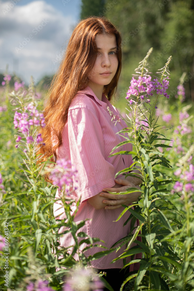 A tall, slender girl of 16-17 years old with long red curly hair in a pink shirt stands in the bushes of pink fireweed flowers, on a sunny summer day, half-length portrait, pink and green colors.
A tall, slender girl of 16-17 years old with long red curly hair in a pink shirt stands in the bushes of pink fireweed flowers, on a sunny summer day, half-length portrait, pink and green colors.