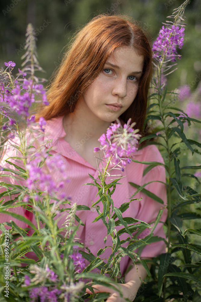 A tall, slender girl of 16-17 years old with long red curly hair in a pink shirt stands in the bushes of pink fireweed flowers, on a sunny summer day, half-length portrait, pink and green colors.
A tall, slender girl of 16-17 years old with long red curly hair in a pink shirt stands in the bushes of pink fireweed flowers, on a sunny summer day, half-length portrait, pink and green colors.