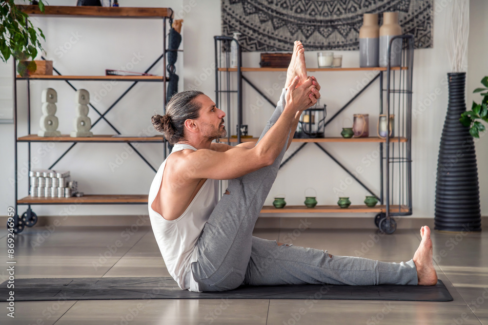 Fotografie Man doing heron yoga in pose on mat