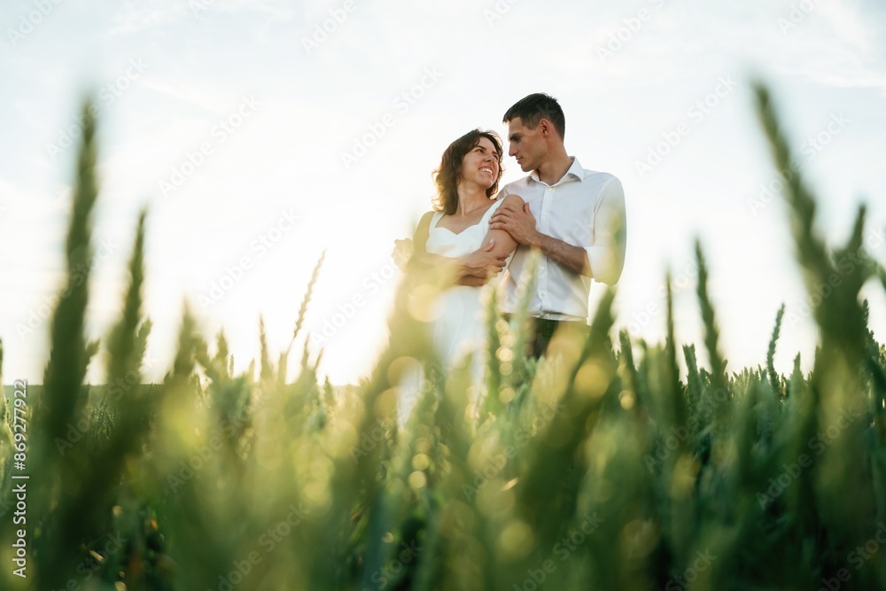 High wheat. Lovely couple are on the agricultural field together High wheat. Lovely couple are on the agricultural field together