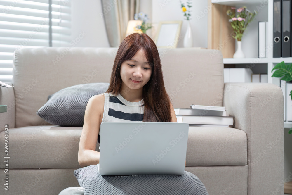 Young Woman Studying Online at Home with Laptop, Engaged in E-Learning, Remote Education, and Online Courses in a Cozy Living Room Setting Young Woman Studying Online at Home with Laptop, Engaged in E-Learning, Remote Education, and Online Courses in a Cozy Living Room Setting