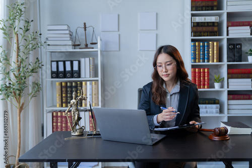 A female attorney is diligently working at her desk in the office.