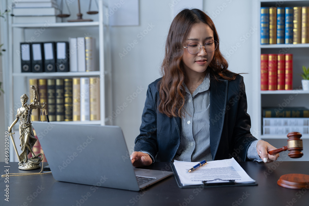 A female attorney is diligently working at her desk in the office. A female attorney is diligently working at her desk in the office.