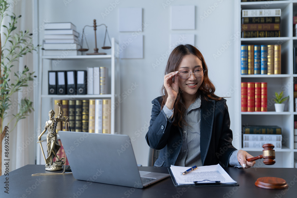 A female attorney is diligently working at her desk in the office. A female attorney is diligently working at her desk in the office.