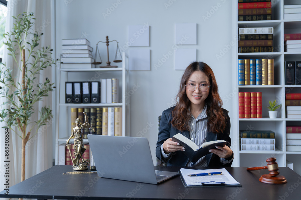 A female attorney is diligently working at her desk in the office.