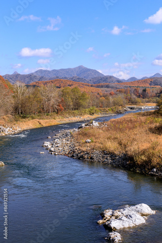 北海道平取町、紅葉した木々の合間を流れる沙流川と日高山脈【11月】