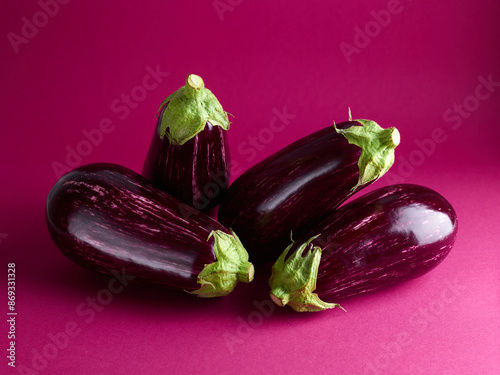 ripe eggplants over magenta background photo