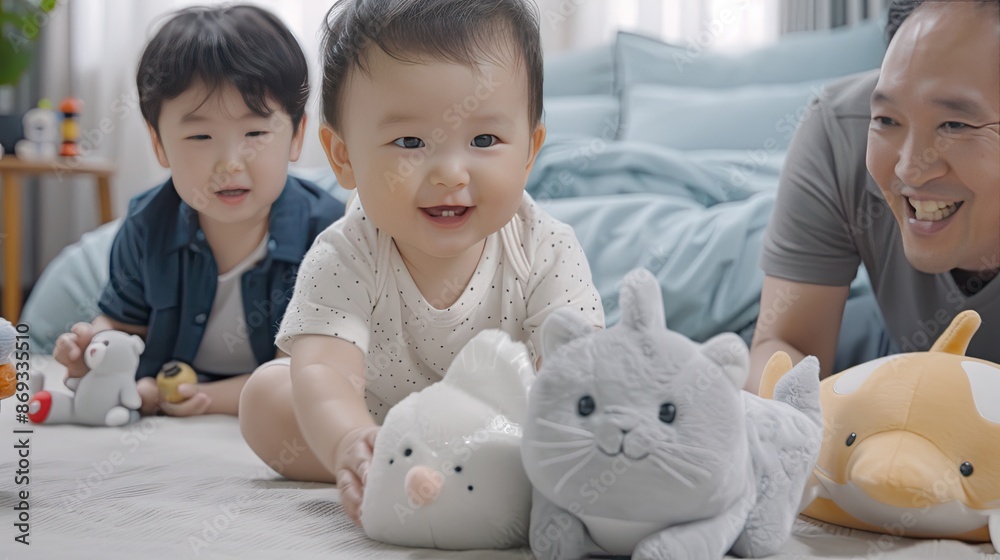 A smiling baby plays with stuffed animals on a couch while a grandfather watches with a smile A smiling baby plays with stuffed animals on a couch while a grandfather watches with a smile