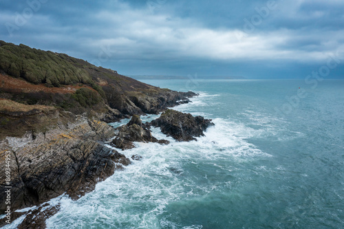 Ocean waves crashing against rocky shoreline in stormy weather