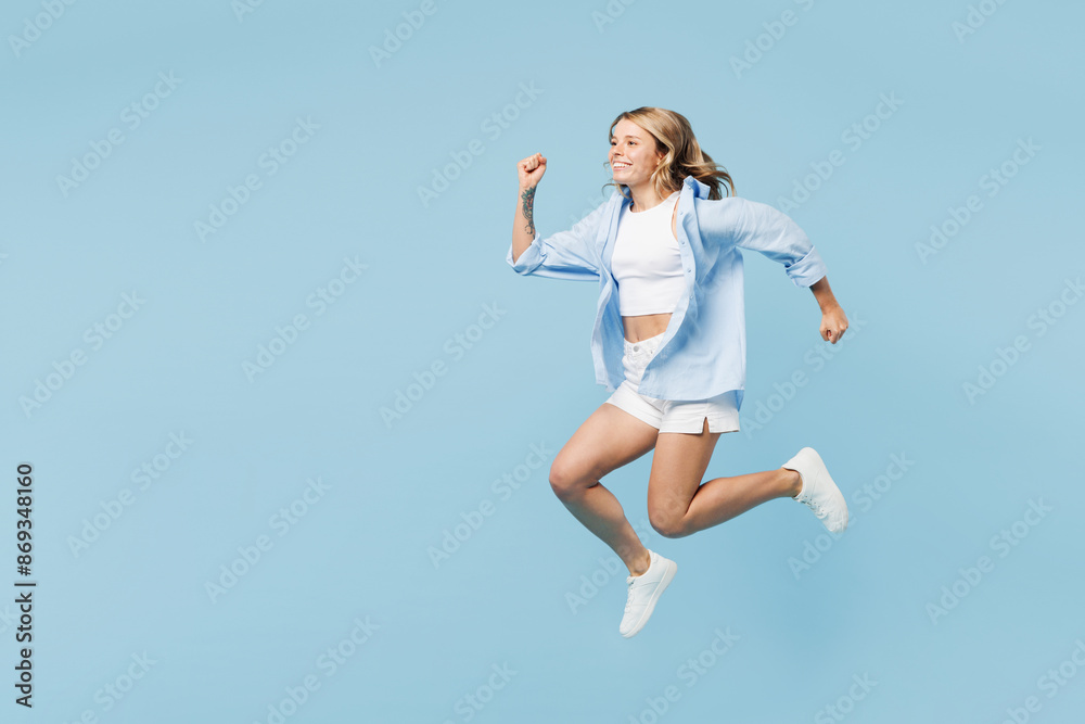 Full body side view young smiling happy cool woman she wears white top shirt casual clothes jump high run fast isolated on plain pastel light blue cyan background studio portrait. Lifestyle concept. Full body side view young smiling happy cool woman she wears white top shirt casual clothes jump high run fast isolated on plain pastel light blue cyan background studio portrait. Lifestyle concept.