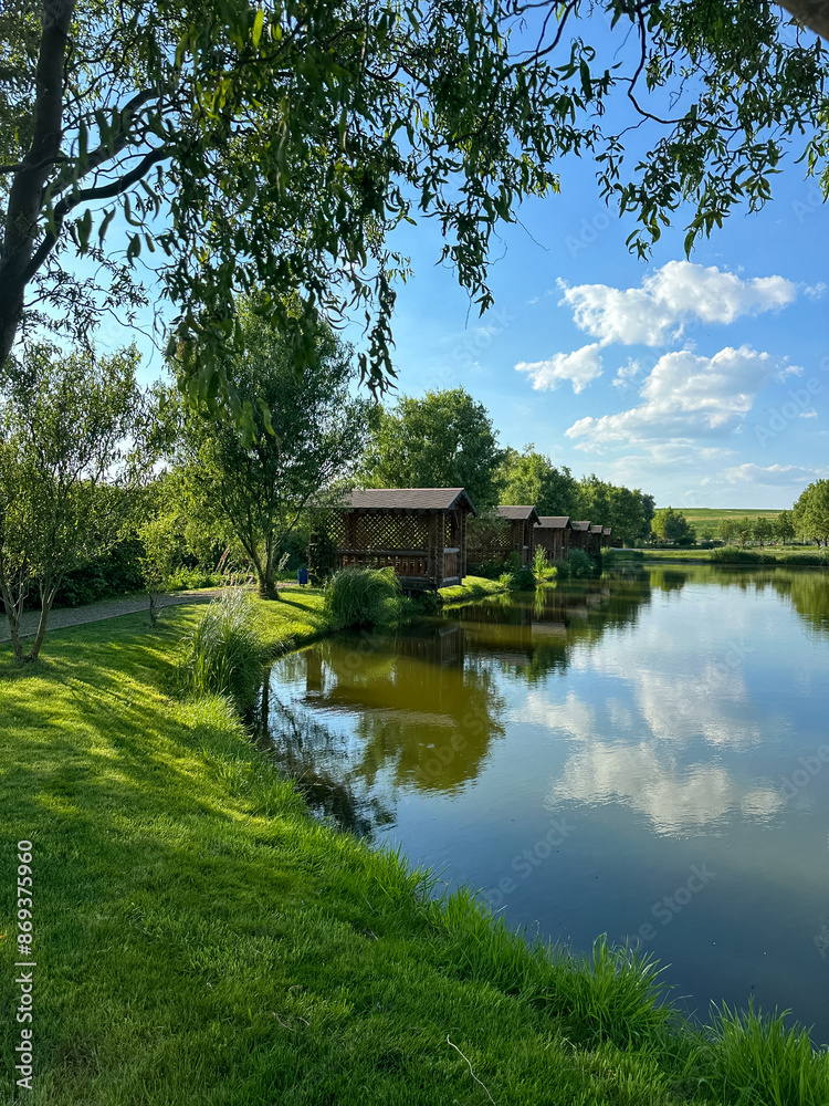 Fototapeta premium Discover the perfect fishing spot on our serene lake. Enjoy tranquil surroundings, clear waters, and the thrill of the catch. Ideal for a relaxing day in nature with friends and family.
