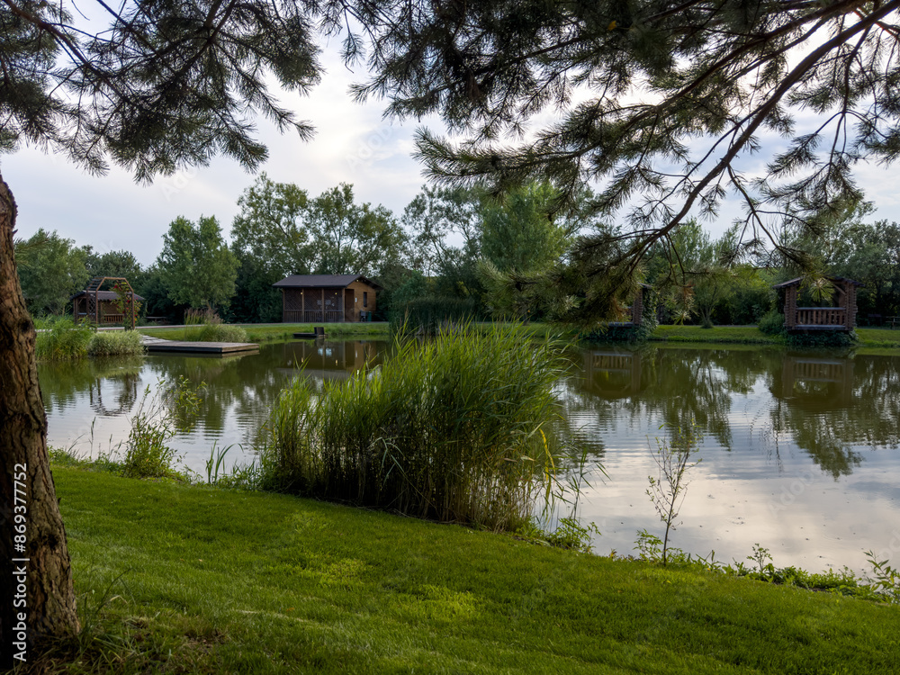 Obraz premium Discover the perfect fishing spot on our serene lake. Enjoy tranquil surroundings, clear waters, and the thrill of the catch. Ideal for a relaxing day in nature with friends and family.