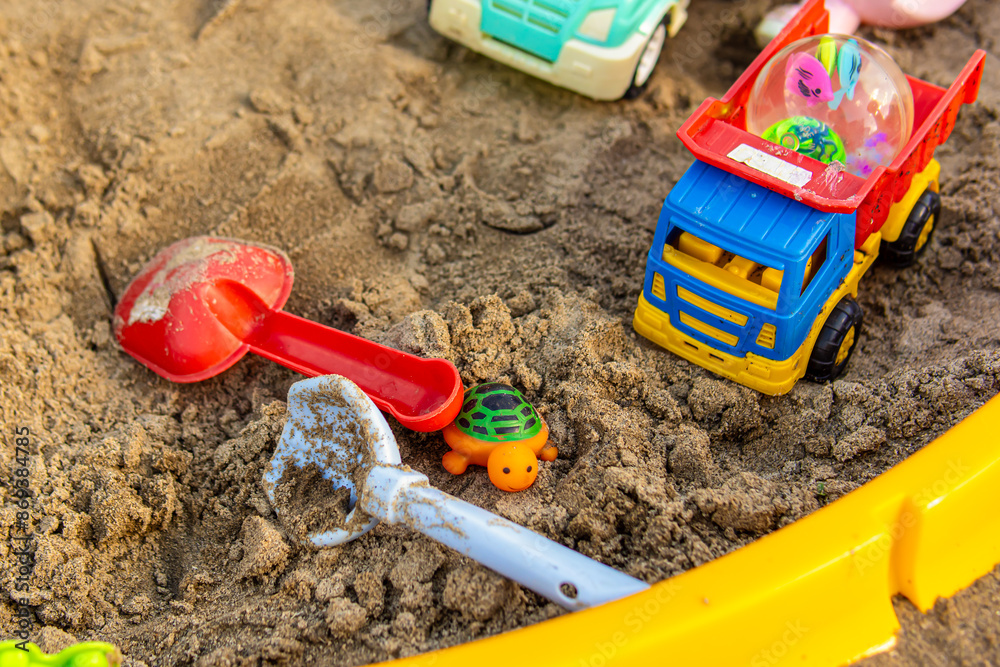 Children's sandbox with toys. Children's plastic shovels for playing in the sand Children's sandbox with toys. Children's plastic shovels for playing in the sand