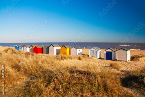 Wooden beach huts in the sand dunes on Southwold beach Suffolk