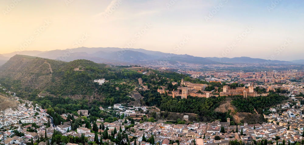 The Alhambra, perched majestically atop a hill in Granada, Spain, bathes in the ethereal beauty of a sunrise The Alhambra, perched majestically atop a hill in Granada, Spain, bathes in the ethereal beauty of a sunrise