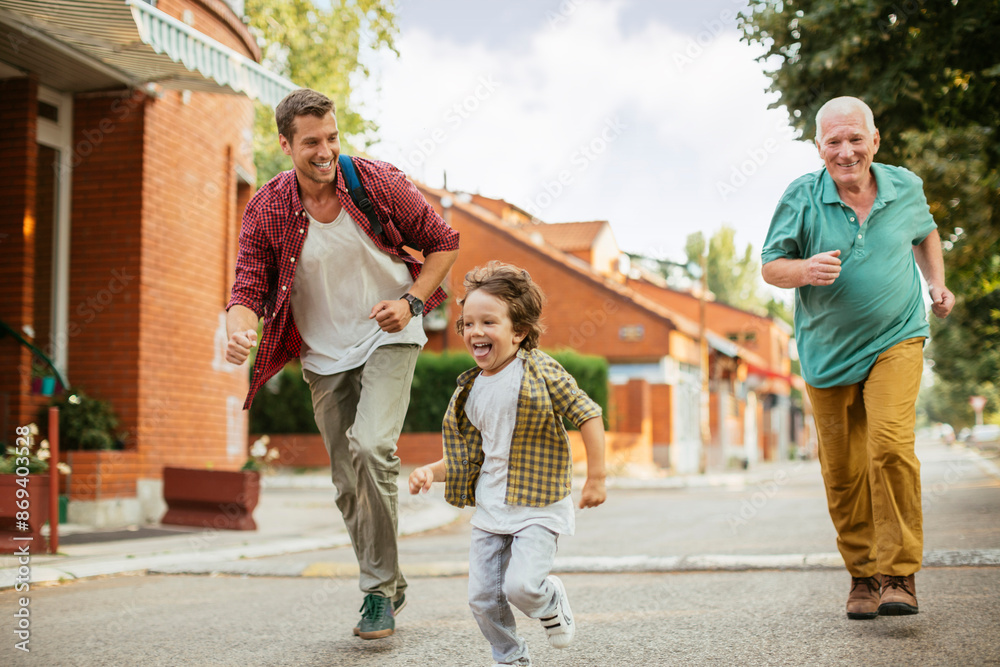 Obraz premium Three generations of family men walking and laughing together outdoors