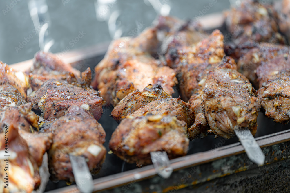 Fried meat strung on skewers is fried over an open fire on a grill. Fried meat strung on skewers is fried over an open fire on a grill.