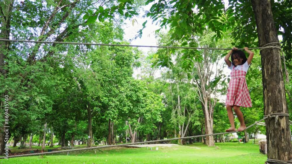 Child enjoying the hanging rope bridge in the park.
