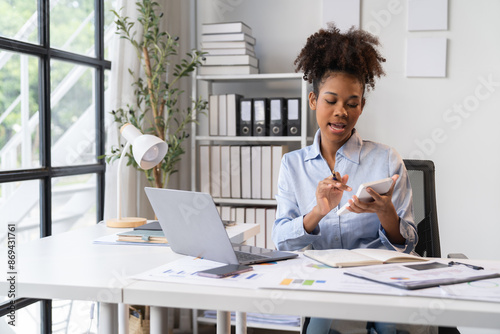 happy young businesswoman African American siting on the chiar cheerful demeanor raise holding coffee cup smiling looking laptop screen.Making opportunities female working successful in the office.	 photo