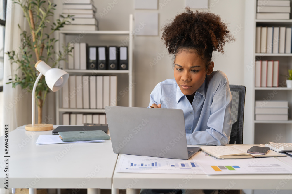 Fototapeta premium Female Entrepreneur. Cheerful African American Businesswoman Working On document and Laptop In Modern Office. Empty Space