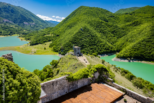 A view of Lake Turano from Mount Antuni, in the village of Castel di Tora, Rieti, Lazio, Italy. The small hermitage above the lake, surrounded by green mountains. Blue sky in summer.