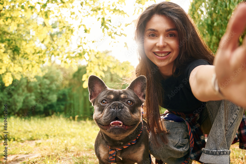 Smiling, making a selfie. Young pretty woman is with her dog in the ...