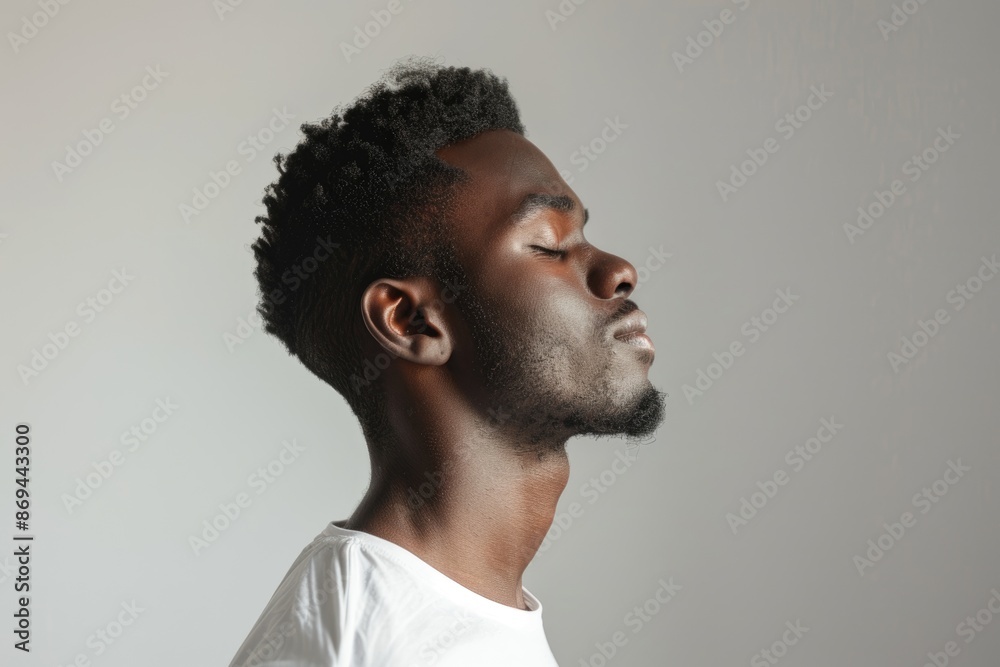 African American man standing peacefully with eyes closed.