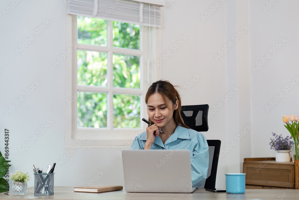 Young Professional Woman Working from Home on Laptop in Bright Modern Home Office with Natural Light Young Professional Woman Working from Home on Laptop in Bright Modern Home Office with Natural Light