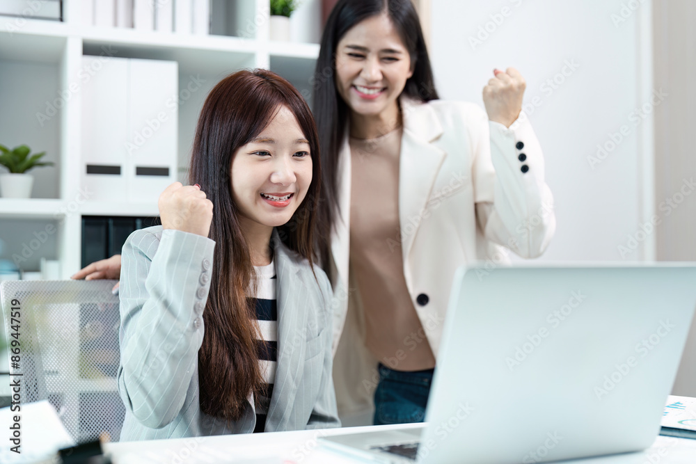 Successful Business Collaboration: Two Women Celebrating Achievement in Modern Office Environment with Laptop