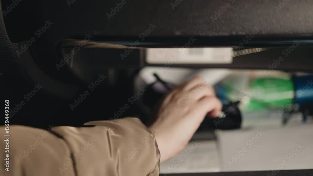 A hand opening a car glove compartment and retrieving an eyeglass case. Captured with a handheld camera, the scene emphasizes everyday car interior actions and organization A hand opening a car glove compartment and retrieving an eyeglass case. Captured with a handheld camera, the scene emphasizes everyday car interior actions and organization