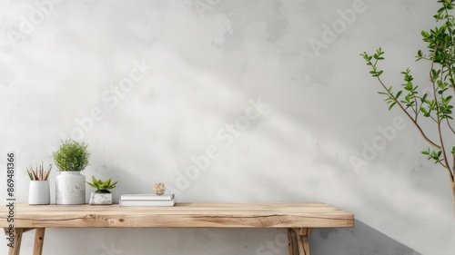 A wooden table with a vase, a book, and a pencil on it. The table is in front of a wall with a plant on it. The table is empty and the room is very clean