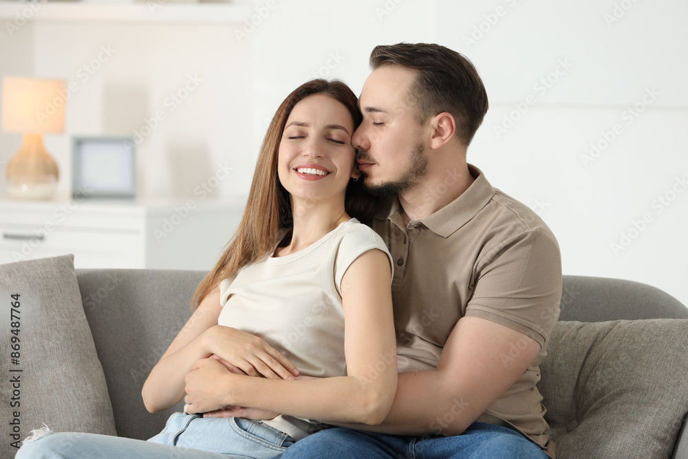 Man hugging his happy girlfriend on sofa at home Man hugging his happy girlfriend on sofa at home
