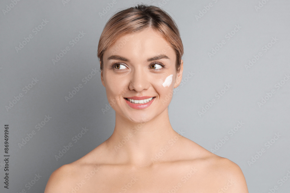 Beautiful woman with cream on her face against gray background Beautiful woman with cream on her face against gray background