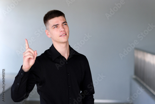 Portrait of young handsome man student or freelancer thinks questioningly and finding solution and typing on laptop computer at home Idea pointing. forward index finger concept photo