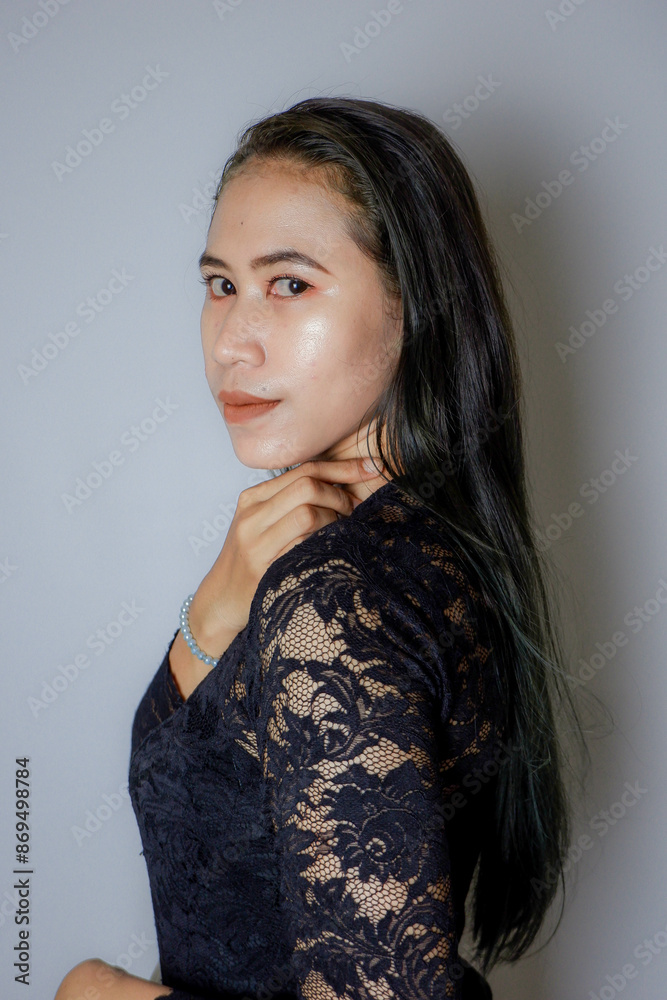 portrait of an Indonesian woman wearing a black kebaya in the studio with a disheveled pose isolated white background portrait of an Indonesian woman wearing a black kebaya in the studio with a disheveled pose isolated white background